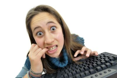 ילדה מחזיקה מקלדת מחשב מול פניה בסביבת עבודה דיגיטלית.